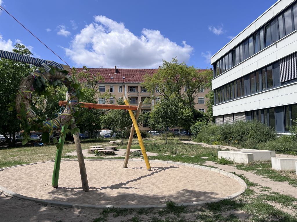 Spielplatz mit Klettergerüst vor dem Schulgebäude