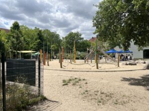 Spielplatz der Schule mit Sandfläche und Spielgeräten