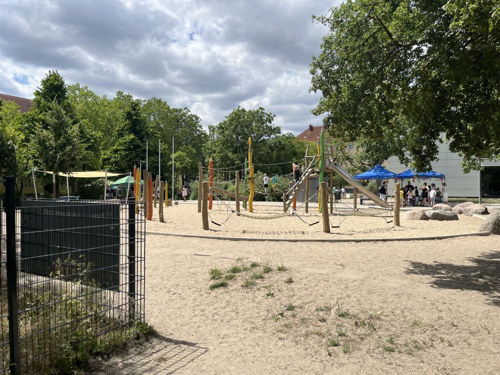 Spielplatz der Schule mit Sandfläche und Spielgeräten