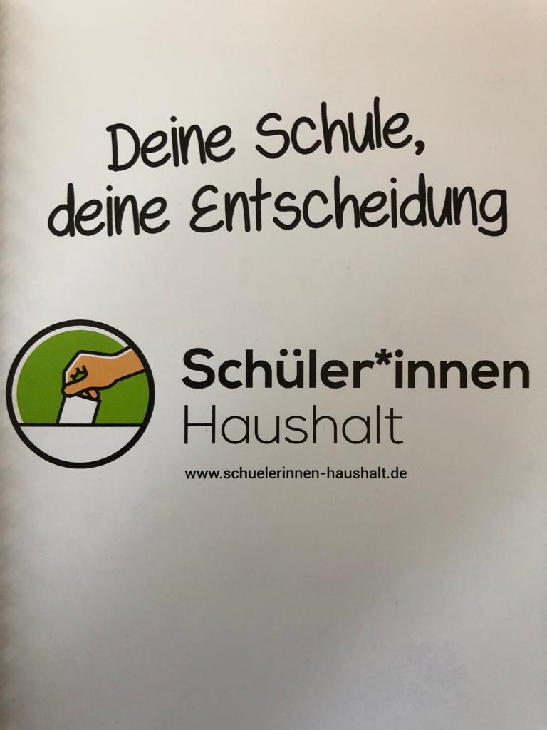 Banner mit dem Motto „Deine Schule, deine Entscheidung“ des Schüler*innen-Haushalts
