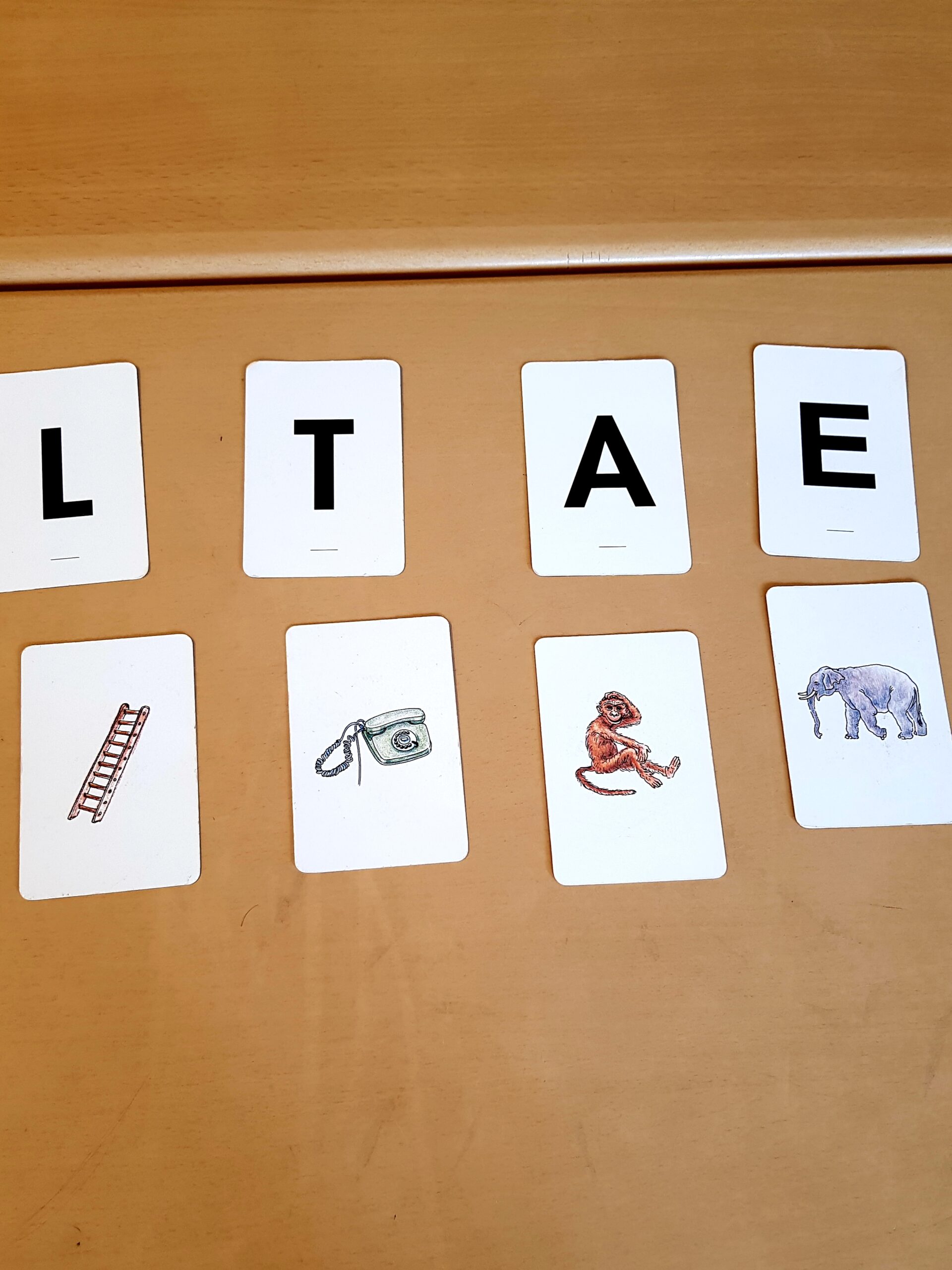 Buchstaben- und Bildkarten liegen auf einem Tisch